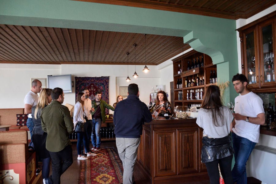 tourists tasting wines and listening to a guide at 'Dio Fili' bar